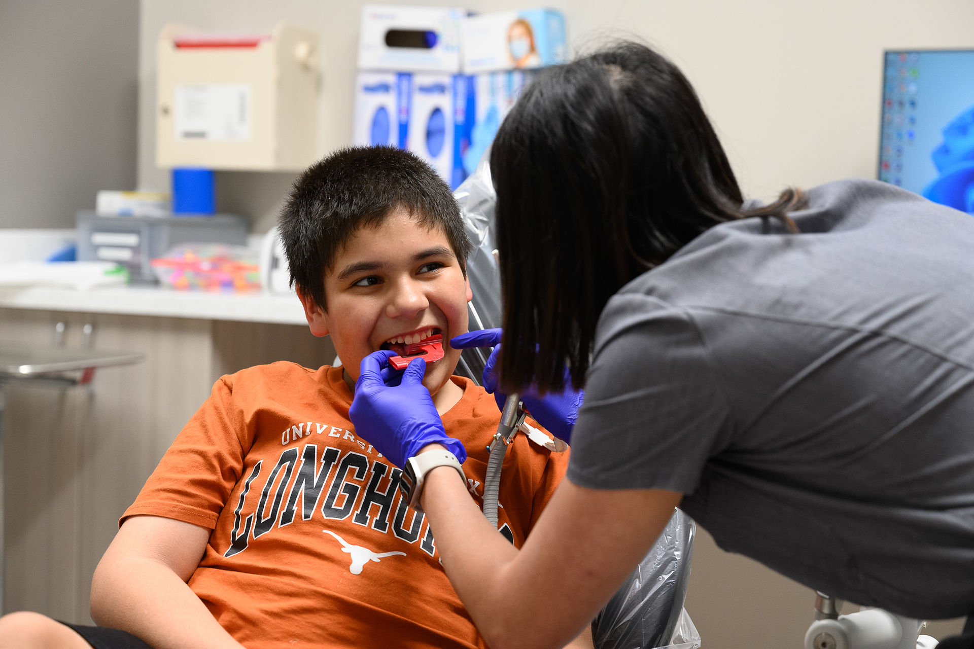Two students perform dental procedure on a young patient