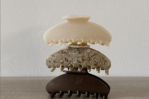 Three Acrasia hair clips stacked neatly, showcasing their sleek design and premium quality.