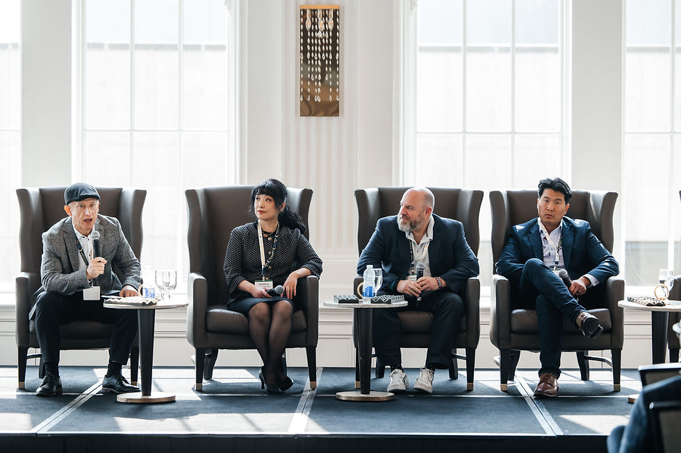 Four panelists sit in armchairs on a bright conference stage, one speaking into a mic while others listen attentively. CanExec Summit 2026