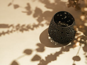 A CORTERRA Clay ceramic candleholder on a table.