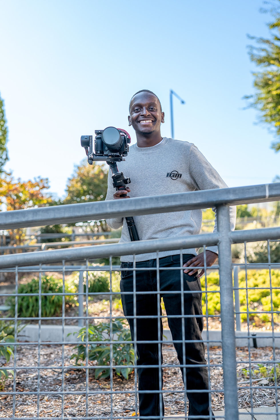 A real estate videographer filming with an agent at a park