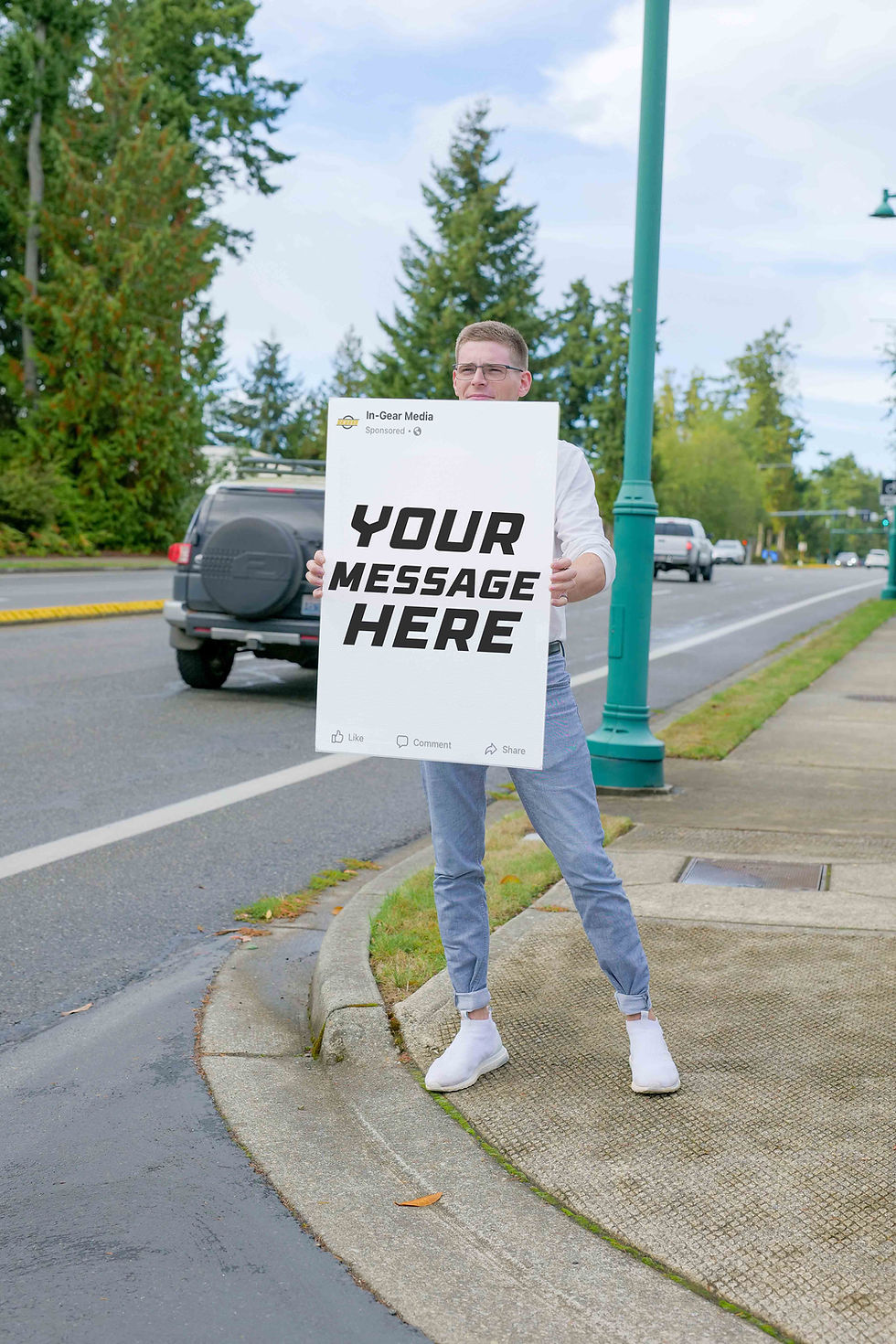Marketer standing on a street corner holding a sign promoting branding services