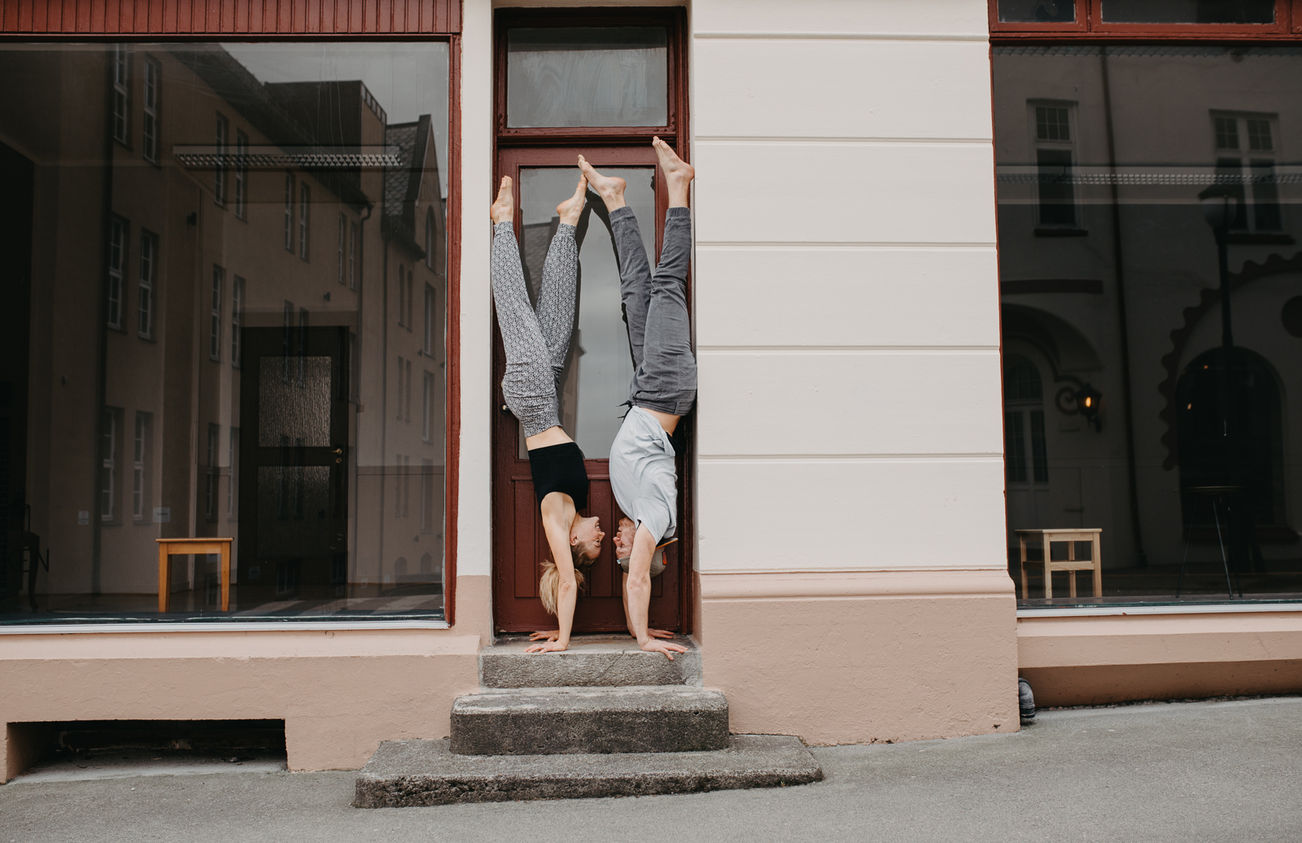 Kjærestepar som står på hendene i en dørkarm