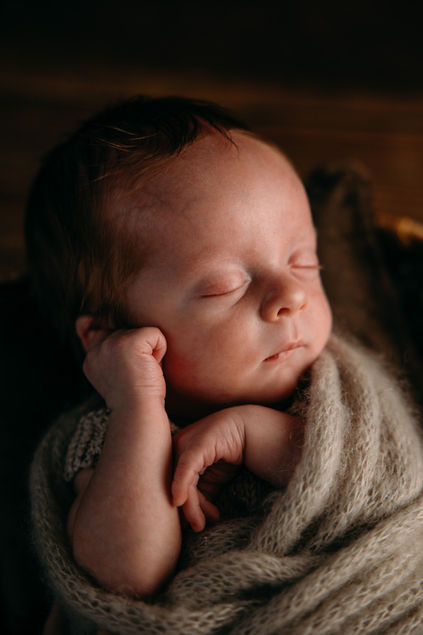 Nærbilde av sovende nyfødt baby i varme og lune jordtoner