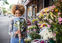 a woman holding a flower bouquet and smiling as she smells it