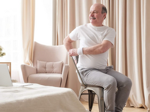 Smiling senior man trying chair yoga for sciatica