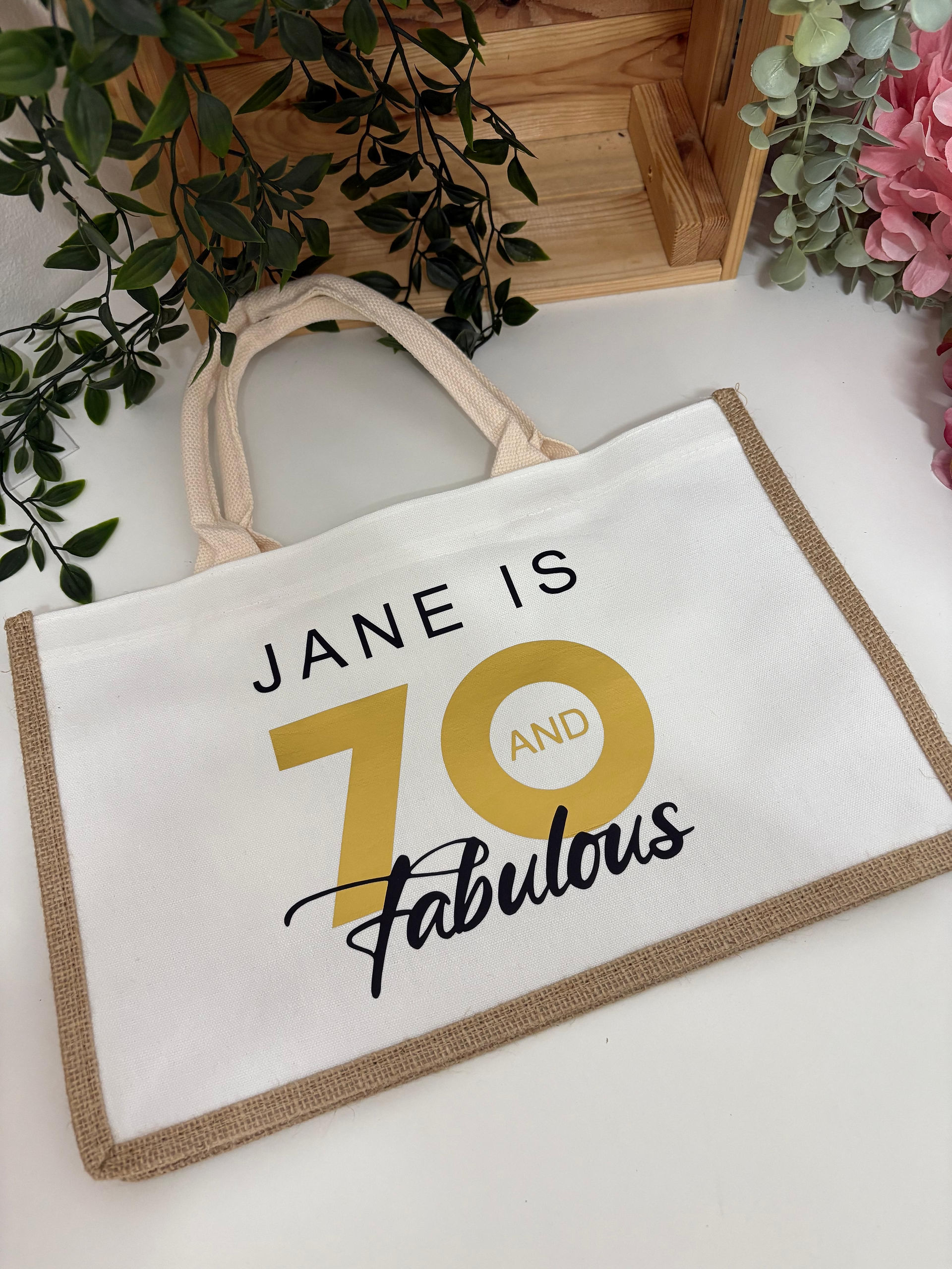 a htv printed canvas tote bag wit the the words "Jane is 70 and fabulous"