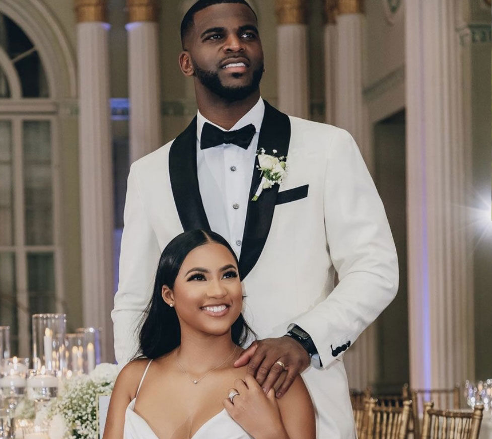 Happy newlywed couple smiling, dressed in an elegant wedding gown and tailored suit