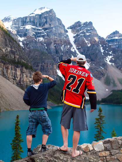 Two young men mimic a classic motion scan of the horizon at the Valley of 10 Peaks in the Canadian Rockies at Lake Moraine, Alberta, Canada.