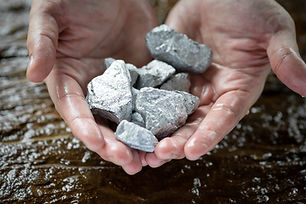 Miners hold in their hands platinum or silver or rare earth minerals found in the mine for