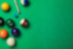 overhead view of billiards table with balls and pool cue