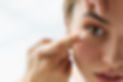 close up of woman applying contact lense
