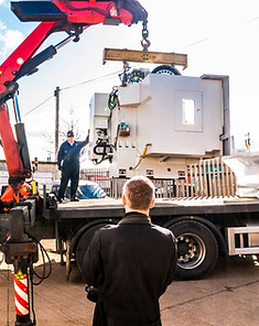 Crane truck lifting heavy CNC machine with hydraulic arm