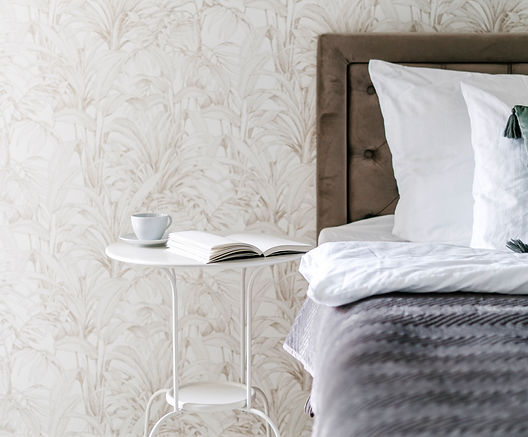 bedroom with wallpaper, nightstand and coffee cup
