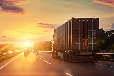 heavy semi-treailer truck with sea shipping container driving highway