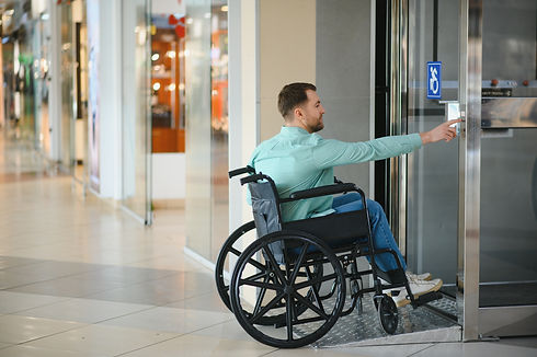 man in wheelchair using accessible door