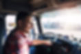 Professional middle aged truck driver in casual clothes driving truck vehicle going for a 