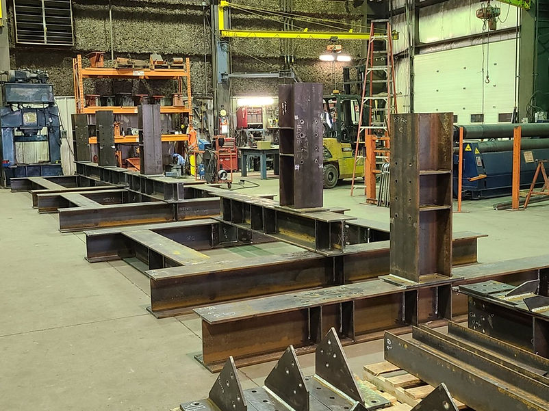 Heavy structural steel beams in a fabrication shop.