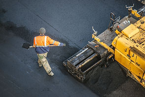 Asphalt worker paving new asphalt