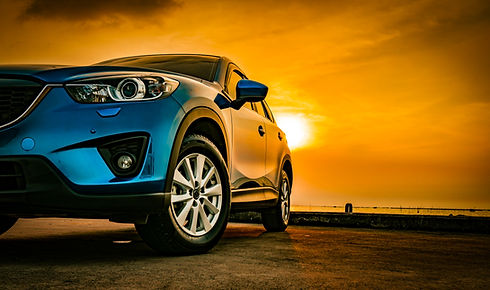 Blue SUV against a vibrant orange sunset