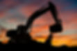 silhouette d'une excavatrice devant le coucher du soleil