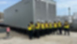 engineers in front of large generator