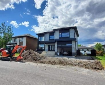 nouvelle maison avec une excavatrice pour faire les terrassements