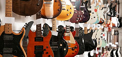 various electric guitars on display in shop