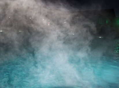 Eau pure et claire dans la piscine thermale. L'eau chaude coule et le brouillard s'élève au dessus de la piscine, de la vapeur. / Pure clear water in the thermal pool. Hot water flows and fog rises above the pool, steam.