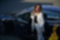 Stylish business woman standing outside her car