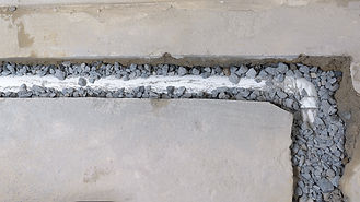 Vue de dessus d'un drain français inachevé partiellement recouvert de roches drainantes