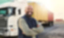 Un ouvrier souriant devant un semi-remorque