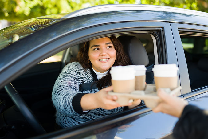 woman picking up coffee from drive-thru