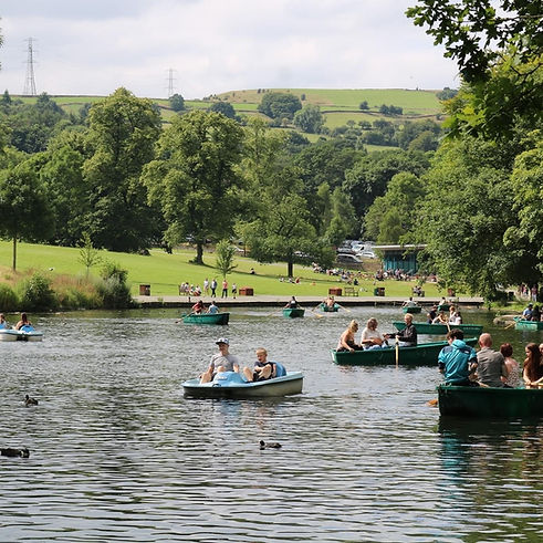 Families in rowing boats on the lake nearby the park