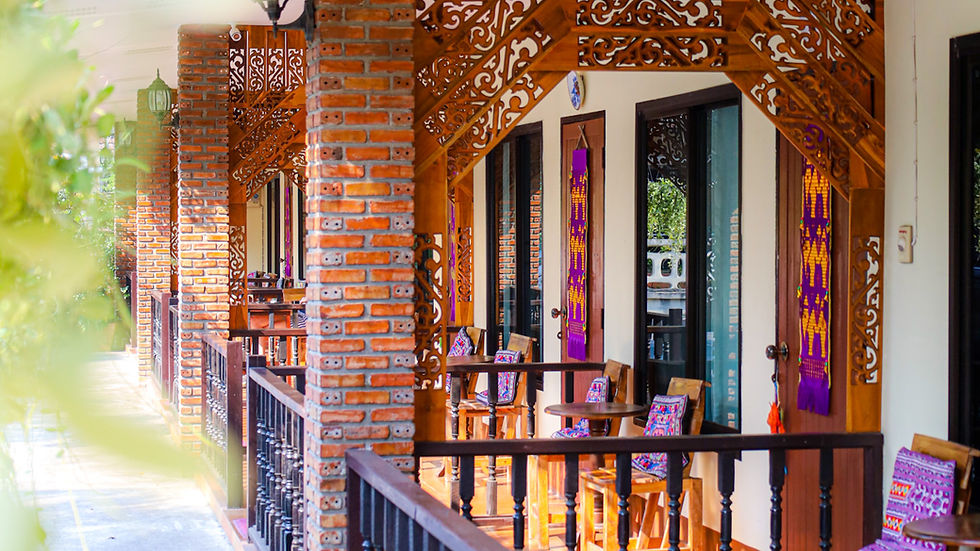 Eye-level view of a peaceful outdoor seating area surrounded by greenery at Baan Gita Chiang Rai