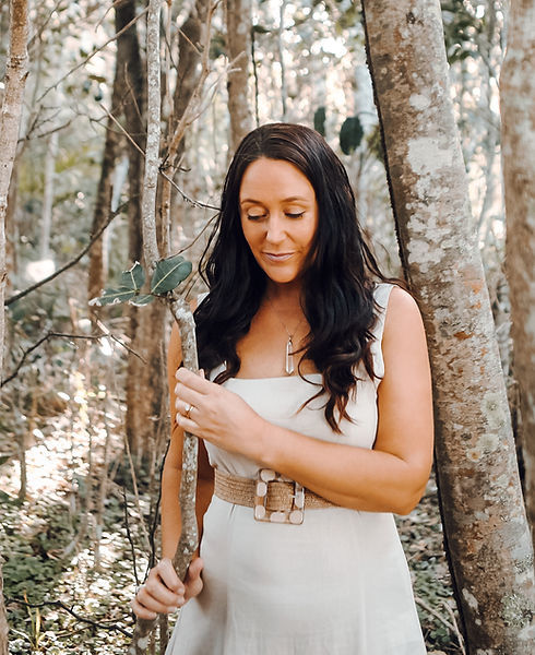 Woman in a forest holding a branch
