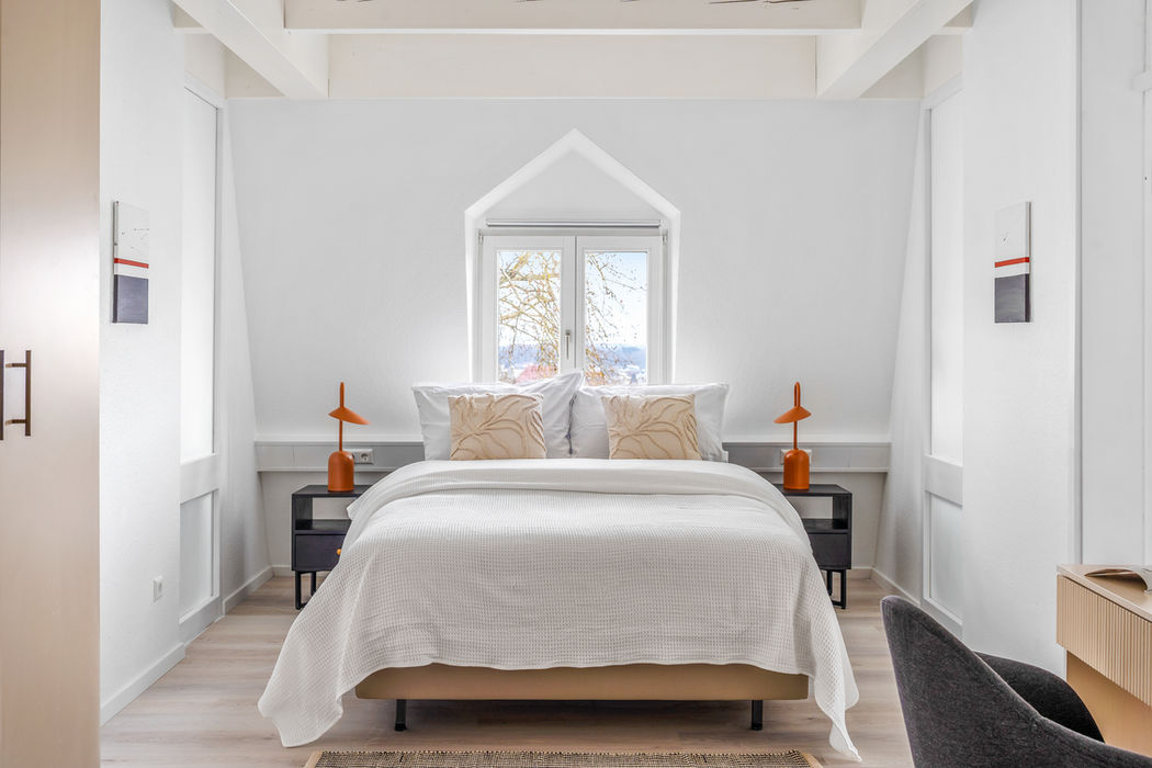 Schlafzimmer im Dachgeschoss mit Giebelfenster und Tageslicht