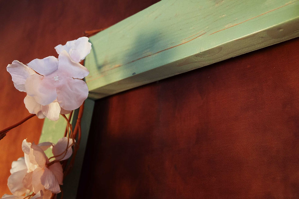 Fleurs artificielles fixées sur le cadre du Jardin des Portraits