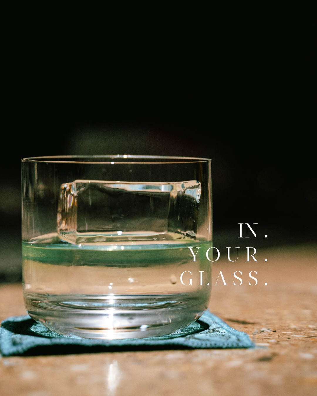 Engraved clear ice cube in a whisky glass