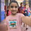 Thumbnail: Girl in a school hallway showing her pink Back To School Sea Turtle T-Shirt to classmates.