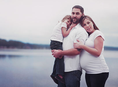 Pregnant woman with her partner and older child. A relaxed family.