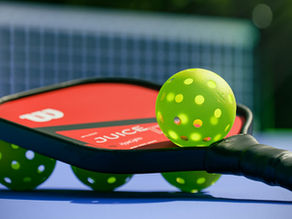 Pickleball paddle and balls on a blue court