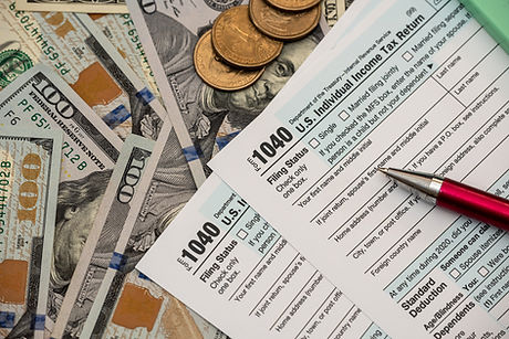 1040 US tax form with pen and dollars on