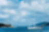 summer-scenery-of-port-fiskardo-white-sail-boat-in-beautiful-tranquil-bay-opposite-rocky-s