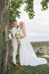 Hochzeitspaar posiert vor See; Brautstrauß