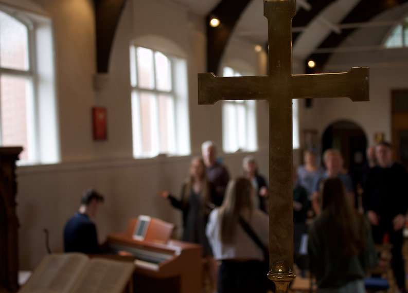 Brass cross with people worshipping.jpeg