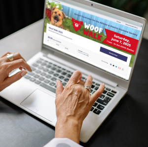 Woman typing on laptop using the Woof Walk Canada Helps page.