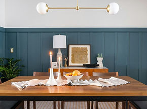 Dining room with deep teal paneled walls