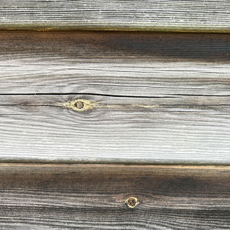 Close up photo of wooden shed panels showing splits and cracks