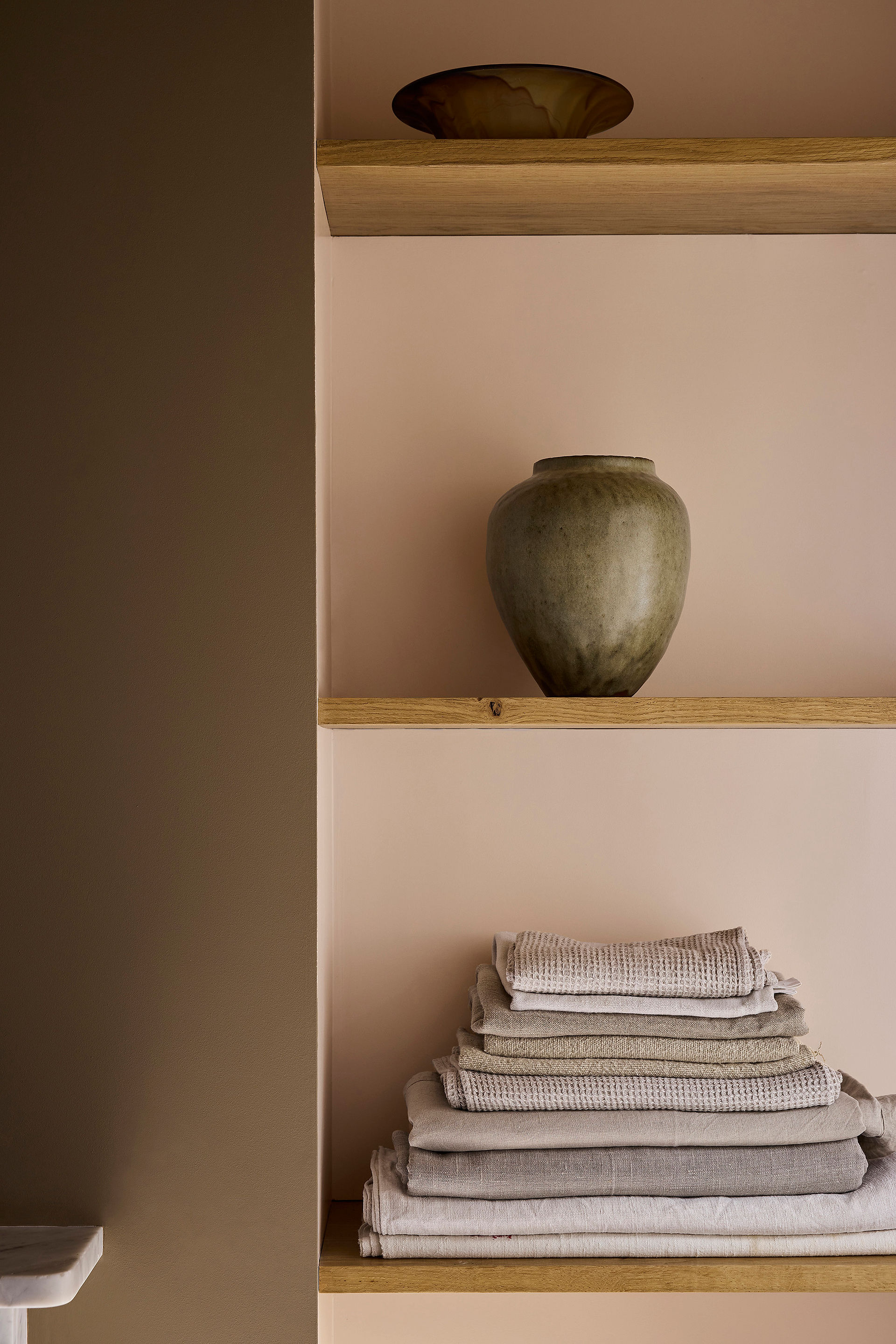 Image from Little Greene of the colour 'Marle' on a wall to the left of a set of shelves.